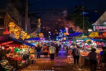 亚洲天堂清迈夜市街拍——彩灯闪烁的夜市摊位前人流熙攘，热带水果与手工艺品琳琅满目，烟火气十足